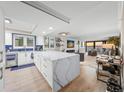 Bright, open kitchen with a large marble island and views of the open-concept living room at 101 Sunset Dr # 103, Sarasota, FL 34236