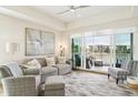 A bright, airy living room with water views, ceiling fan, and stylish furnishings with a sliding glass door to the outside deck at 10530 Boardwalk Loop # 201, Lakewood Ranch, FL 34202