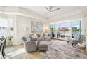 A bright, airy living room with water views, ceiling fan, and stylish furnishings with a sliding glass door to the outside deck at 10530 Boardwalk Loop # 201, Lakewood Ranch, FL 34202