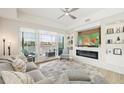 A bright, airy living room has water views, a modern fireplace, and custom shelving with a sliding glass door to the outside deck at 10530 Boardwalk Loop # 201, Lakewood Ranch, FL 34202
