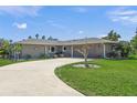 A beautiful single-story home featuring a well-manicured lawn and a winding driveway at 1208 Angela Maria Rd, Sarasota, FL 34243