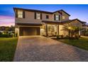 Charming two-story home with a well-manicured lawn, brick-paved driveway, and a two-car garage, enhancing curb appeal at 16455 Whale Grey Pl, Bradenton, FL 34211