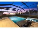 Relaxing screened-in pool and spa overlooking a peaceful pond with stunning sunset views, perfect for outdoor entertaining at 16455 Whale Grey Pl, Bradenton, FL 34211