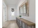 Elegant foyer with tile floors, a console table, decorative mirror, and stylish front door at 16719 Ellsworth Ave, Bradenton, FL 34202