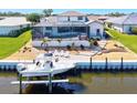 Beautiful waterfront backyard featuring a screened-in pool, dock, and boat lift, perfect for outdoor living at 347 Ardenwood Dr, Englewood, FL 34223