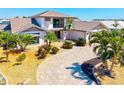 Beautiful home featuring palm trees, a paver driveway, and lush landscaping at 347 Ardenwood Dr, Englewood, FL 34223