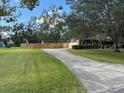 Long driveway leading to a home with a fenced backyard and large grassy area for outdoor activities at 411 El Greco Dr, Brandon, FL 33511
