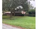 A charming two-story house with a lush green lawn and mature trees offering shade and curb appeal at 411 El Greco Dr, Brandon, FL 33511