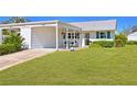 Inviting home exterior features a well-kept lawn, carport, and cozy front porch area at 4411 Mount Vernon Dr, Bradenton, FL 34210