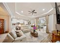 Open-concept living area with tray ceiling, hardwood floors, and access to outdoor space at 4691 Claremont Park Dr, Bradenton, FL 34211