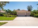 Charming single-story home with a tile roof, three-car garage, and well-manicured landscaping at 4740 Carrington Cir, Sarasota, FL 34243