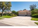 Charming single-story home with a tile roof, three-car garage, and well-manicured landscaping at 4740 Carrington Cir, Sarasota, FL 34243