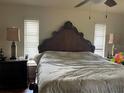 Comfortable bedroom with hardwood floors, ceiling fan, and natural light from two windows at 5180 Guava Ter, Port Charlotte, FL 33981