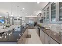 Open concept kitchen with gray cabinets, a large island, stainless steel appliances, and marble flooring at 5557 Long Shore Loop, Sarasota, FL 34238