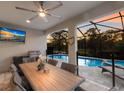 The outdoor living space features a covered patio, outdoor kitchen, TV, and pool at 5557 Long Shore Loop, Sarasota, FL 34238