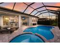 Sparkling pool and hot tub in a screened lanai with outdoor kitchen and TV at 5557 Long Shore Loop, Sarasota, FL 34238