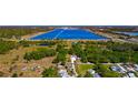 Expansive aerial view of a property with a large lake and surrounding greenery, offering a tranquil setting at 5860 Brown Ln, Sarasota, FL 34232