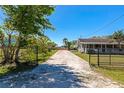 Long private driveway leading to a well-maintained home with a charming front porch at 5860 Brown Ln, Sarasota, FL 34232