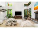Modern living room boasts soaring ceilings, large windows, stylish decor, and plenty of natural light at 587 47Th St, Sarasota, FL 34234