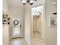 Inviting entryway featuring tile floors, decorative mirror, and a front door with glass detailing at 6638 Willowshire Way, Bradenton, FL 34212