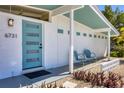 A cozy front porch with blue door and seating, enhancing curb appeal and providing a welcoming entrance at 6731 Northampton Pl, Bradenton, FL 34207