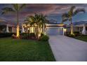 Charming single-story home featuring a lush landscaped yard, palm trees, and a two-car garage at 7012 White Willow Ct, Sarasota, FL 34243