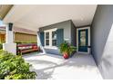 Inviting front porch features a bench with a view, an accent door, and tasteful landscaping for added curb appeal at 7012 White Willow Ct, Sarasota, FL 34243