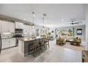 Open-concept kitchen with stainless steel appliances, a large island, pendant lighting, and views into the living area at 7012 White Willow Ct, Sarasota, FL 34243