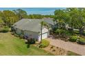 An aerial view of a charming home featuring a brick driveway, lush landscaping, and a well-manicured lawn at 7133 Victoria Cir, University Park, FL 34201