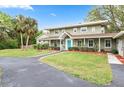 Charming two-story home with a well-maintained lawn and landscaping with a driveway at 730 Rellim Ln, Sarasota, FL 34232