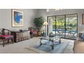 Living room with tile floors, glass coffee table, and sliding glass doors to the pool at 7300 Wax Myrtle Way, Sarasota, FL 34241