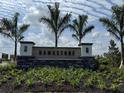 Beautiful monument sign for Hawkstone community featuring stone accents, lush landscaping, and palm trees at 7561 Nighthawk Dr, Sarasota, FL 34241