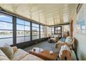 Bright sunroom with large windows offering scenic lake views, comfortable seating, and serene ambiance at 772 Imperial Dr, North Port, FL 34287