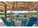 Inviting waterfront outdoor seating area with a tiki hut, perfect for relaxation and enjoying scenic views at 1410 San Jose Dr, Englewood, FL 34223