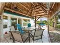 Outdoor dining area under a tiki hut featuring views of the canal and pool at 1410 San Jose Dr, Englewood, FL 34223