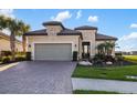 Beautiful single-story home with a paver driveway and a well-manicured front yard showcasing beautiful tropical landscaping at 15169 Vivaldi Dr, Nokomis, FL 34275