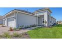 Exterior of home with a paved walkway, green lawn, and tasteful plantings to enhance curb appeal at 18137 Franklin Park Ct, Venice, FL 34293