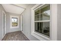 Covered porch with tiled flooring, and two large windows showing outdoor views and letting in natural light at 18137 Franklin Park Ct, Venice, FL 34293
