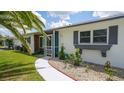 Charming single-story home showcasing a blue front door and decorative rock landscaping at 22201 Olean Blvd, Port Charlotte, FL 33952