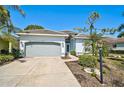 Inviting single-story home featuring a well-manicured yard and a concrete driveway at 2311 Falcon Trace Ln, Nokomis, FL 34275