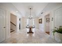 Elegant foyer with marble floors, a grand chandelier, and a view of the staircase at 236 Saint James Park, Osprey, FL 34229