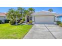 Inviting home featuring a lush lawn, mature landscaping, and a two-car garage for convenient parking at 2871 Royal Palm Dr, North Port, FL 34288