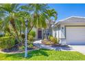 The property boasts of tropical landscaping and a paved walkway to the front door entrance of this home at 2871 Royal Palm Dr, North Port, FL 34288