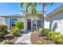 A welcoming entryway featuring elegant landscaping, a neutral color palette, and a cozy seating area at 2871 Royal Palm Dr, North Port, FL 34288