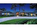 Stunning exterior view of a home with a paver driveway, lush landscaping, and elegant architectural design at 316 W Royal Flamingo Dr, Sarasota, FL 34236