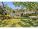 Charming home with well-maintained lawn, lush landscaping, and a welcoming covered front porch at 325 12Th W Ave, Palmetto, FL 34221