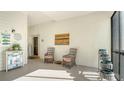 Screened in patio area with two chairs, art and view of the exterior at 4104 128Th W St # 704, Cortez, FL 34215