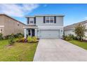 Two-story home with neutral paint, a two-car garage, and well-manicured landscaping at 4231 Autumn Fog Ct, Palmetto, FL 34221