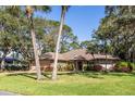 Charming single-story home with a tile roof, mature trees and a well-manicured lawn and a two car garage at 4701 Pine Harrier Dr, Sarasota, FL 34231