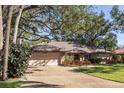 Charming single-story home with a tile roof, mature trees and a well-manicured lawn and a two car garage at 4701 Pine Harrier Dr, Sarasota, FL 34231